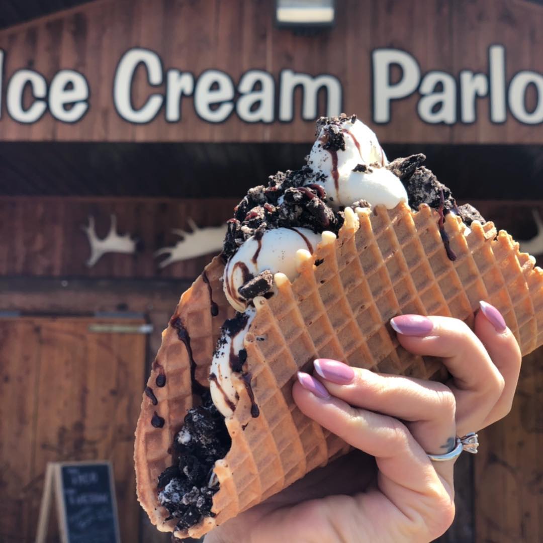 Covered wooden deck with picnic tables outside Big Moose